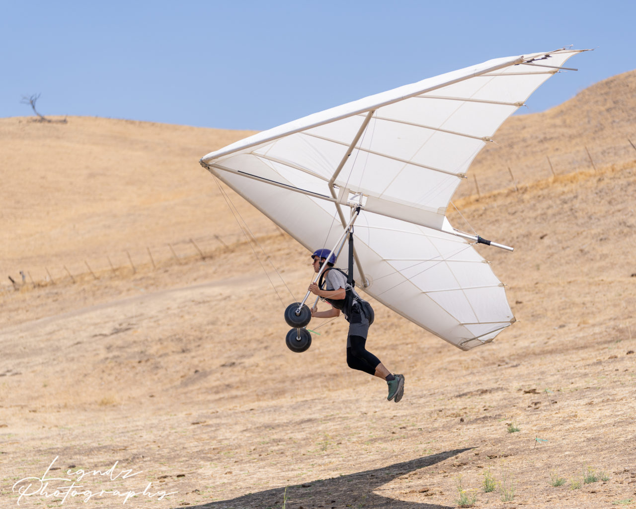 Hang gliding student flying over the training hill
